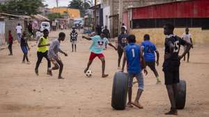 Crianças jogam à bola, durante uma reportagem da agência Lusa no bairro do Sambizanga, dias após da visita do Papa Leão XIV a Angola, em Luanda, Angola, 22 de abril de 2026. No Sambizanga, bairro de Nagrelha e Bangão, Mantorras e William Carvalho, Dádiva pousa na rua cor-de-rosa, a do mural que junta políticos como Neto e Savimbi, na Luanda dos contrastes, onde a pobreza se esconde atrás dos arranha-céus e se mostra sem vergonha nos musseques. (ACOMPANHA TEXTO DA LUSA DO DIA 27 DE ABRIL DE 2026). JOSÉ SENA GOULÃO/LUSA