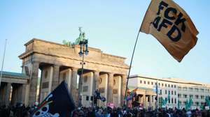 epa13220463 A participant waves a flag that reads 'FCK AFD' during a rally at the Brandenburg Gate in Berlin, Germany, 07 September 2026. The protest was scheduled a day after the far-right Alternative for Germany party (AfD) won the election in the regional state of Saxony Anhalt by a wide margin.  EPA/CLEMENS BILAN