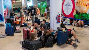 Passengers lay on the floor as they wait for their flight due to a strike of the handling company, Groundforce, which is causing major disruption in the Lisbon Airport, causing the cancelation of dozens of flights, in Lisbon, Portugal, 17 July 2021. Groundforce workers are protesting against colective dismissal of workers and low salaries. JOSE SENA GOULAO/LUSA