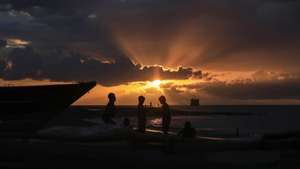 epa08587343 East Timorese children play on the beach during sunset in Dili, East Timor, also known as Timor Leste, 06 August 2020.  EPA/ANTONIO DASIPARU