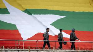 epa10987635 Myanmar police officers walk in front of the Myanmar national flag during the 2026 FIFA World Cup qualification soccer match between Myanmar and North Korea in Yangon, Myanmar, 21 November 2023.  EPA/NYEIN CHAN NAING