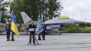 epa11525679 A handout picture made available by the Presidential Press Service shows Ukrainian President Volodymyr Zelensky speaking to servicemen next to an American single-engine supersonic multirole fighter F-16 jet during a ceremony to mark Air Force Day of the Armed Forces of Ukraine at an undisclosed location in Ukraine, 04 August 2024, amid the Russian invasion. Zelensky emphasized that the number of F-16 aircraft and trained pilots is still insufficient, as the country waits for additional fighters from partner countries.  EPA/PRESIDENTIAL PRESS SERVICE HANDOUT  HANDOUT EDITORIAL USE ONLY/NO SALES