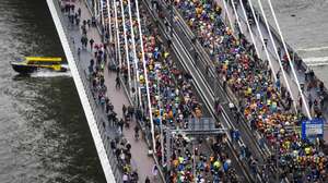 epa10575340 Athletes run across the Erasmus Bridge during the 42nd edition of the NN Marathon Rotterdam in Rotterdam, the Netherlands, 16 April 2023.  EPA/JEFFREY GROENEWEG