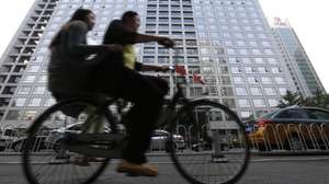 epa04838179 Chinese cyclists cycle past the China Securities Regulatory Commission building in Beijing, China, 09 July 2015. The country's securities regulator said on 08 July that big shareholders who hold more than five per cent of a company's shares must not reduce their holdings in the coming six months.  EPA/HOW HWEE YOUNG