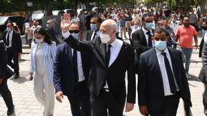epa09386130 A handout photo made available by the Tunisian Presidency shows Tunisian President Kais Saied (C) gesturing among supports as he walks protected by security guards in Habib Bourguiba Avenue, Tunis, Tunisia, 01 August 2021. Two Members of the Parliament were reportedly arrested on 01 August brining to three the number of MPs detained since Saied sacked prime minister Mechichi and suspended the parliament on 25 July. Saied said he acted within the constitution as US Secretary of State Antony Blinken called for the return 'to the democratic path' in the country.  EPA/PRESIDENCY OF TUNISIA HANDOUT  HANDOUT EDITORIAL USE ONLY/NO SALES