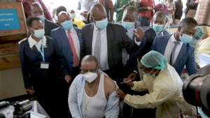 epa09021111 Vice President and Minister of Health and Child Care Constantino Chiwenga (C, sitting) receives first shot of Covid-19 vaccine, at Wilkins Hospital in Harare, Zimbabwe, 18 February 2021.  Chiwenga received the first shot of Sinopharm vaccine at the beginning of the vaccination campaign in the country that received 200,000 doses from China and is expected to vaccinate people over 60 and health workers.  EPA/AARON UFUMELI