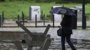 Uma mulher passa numa área inundada na zona de Benfica em Lisboa, 30 de novembro de 2023. O Instituto Português do Mar e da Atmosfera (IPMA) elevou hoje para laranja o aviso nos distritos de Lisboa, Setúbal e Santarém devido à previsão de períodos de chuva, por vezes forte e persistente. TIAGO PETINGA/LUSA