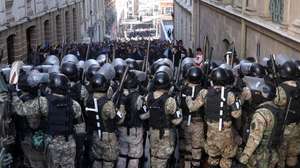 epaselect epa11440767 Military police line up in front of supporters of Bolivian President Luis Arce during a protest against military personnel trying to enter the government headquarters in La Paz, Bolivia, 26 June 2024. A group of soldiers led by Bolivian Army general commander Juan Jose Zuniga entered Plaza Murillo on 26 June 2024 using a tank to knock down the door of the government headquarters. The soldiers withdrew after Bolivian President Luis Arce changed the heads of the entire military high command, describing the action as a coup attempt.  EPA/Luis Gandarillas