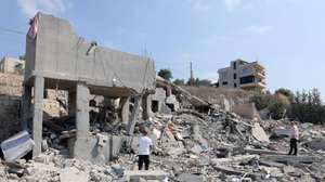 epa13170748 People inspect a damaged building after an Israeli airstrike on the village of Ansar, southern Lebanon, 15 August 2026. At least seven people were killed and two others injured in an Israeli airstrike on Ansar village early 15 August, according to the Lebanese official news agency (NNA).  EPA/WAEL HAMZEH