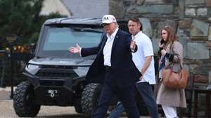 epa13236589 US President Donald Trump (C) gestures as he visits Trump International Golf Links and Hotel in Doonbeg, Ireland, 13 September 2026. Trump is on a two-day visit to Ireland that includes attending the Amgen Irish Open at his Doonbeg golf course.  EPA/NEIL HALL