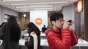 epa11743705 A shopper looks at the new Xiaomi REDMI K80 phone in Beijing, China, 27 November 2024. Chinese consumer electronics company Xiaomi unveiled its new REDMI K80 phone.  EPA/JESSICA LEE