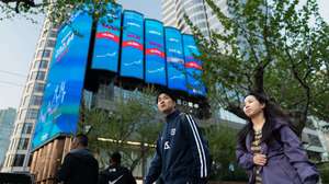 epa12031409 People walk near screens showing the latest stock exchange and economic data in Shanghai, China, 14 April 2025. Shanghai Stock Exchange edged higher at the opening on 14 April as Chinese stock exchanges have introduced daily caps on net share sales by hedge funds and prominent retail investors with an aim to fortify market stability amid the intensifying storm of a trade war with the United States.  EPA/ALEX PLAVEVSKI