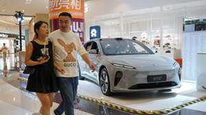 epa11407061 People walk beside a NIO ET5 electric car on display in a shopping mall in Beijing, China, 13 June 2024. Beijing urges the European Union to reconsider tariffs on Chinese electric vehicles and to stop going further in what they say is the 'wrong direction' to protect its auto industry from competition, according to China's state news agency Xinhua. China said it would take measures to safeguard its interests after the European Commission announced on 12 June it would impose extra duties of up to 38.1 percent on imported Chinese electric vehicles from July 2024.  EPA/WU HAO