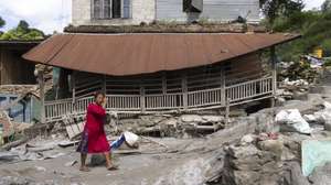 epa13200028 A woman walks in front of a damaged house following flash floods along the banks of the Trishuli River in Dhading district, Nepal, 30 August 2026. More than 700 people were killed, and hundreds remain missing across northern Nepal after a glacial collapse and avalanche triggered flash floods and mudslides along the Bhotekoshi and Trishuli river valleys near the Nepal-Tibet border, causing widespread destruction to settlements and infrastructure, according to the National Disaster Risk Reduction and Management Authority (NDRRMA).  EPA/NARENDRA SHRSTHA