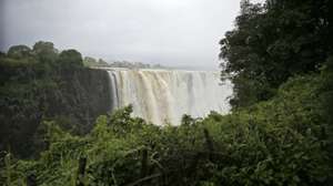 epa08249859 A general view towards the Victoria Falls, Zimbabwe, 26 February 2020. This time of the year the falls are at their peak and generate mists that can be seen from more than 20 kilometers away. The mist also sustains a rain forest-like ecosystem adjacent to the falls. As much as 540 million cubic meters of water fall over the edge every single minute.  EPA/AARON UFUMELI