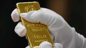epa12062283 A Bank of Thailand staff member checks the authenticity of a gold bar after receiving the donation, during the handover ceremony at the Bank of Thailand in Bangkok, Thailand, 29 April 2025. The Bank of Thailand received a 10-kilogram gold bar donated by followers of Buddhist monk Luangta Maha Bua to support national reserves.  EPA/NARONG SANGNAK