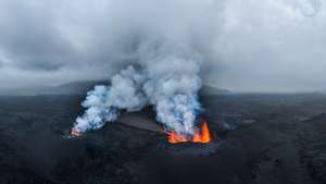 epa12248363 Smoke and lava rise from a volcano eruption near Reykjanes, Iceland, 19 July 2025. According to the Icelandic Meteorological Office, a magma flow began at the Sundhnuk crater range on 16 July.  EPA/JAKOB VEGERFORS
