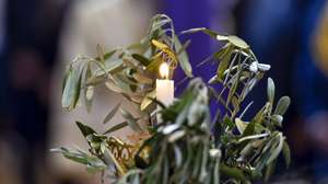 epa09894263 A Lebanese Orthodox Christian carries a candle with an olive branch during a Palm Sunday mass at the Saint George Cathedral in downtown Beirut, Lebanon, 17 April 2022. Palm Sunday for Christian Orthodox devotees symbolically marks the entry of Jesus Christ into Jerusalem, signaling the start of the Holy Week before Easter.  EPA/WAEL HAMZEH