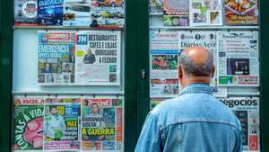 Um homem lê as capas dos jornais exposta na vitrina de um quiosque de rua em Ponta Delgada, ilha de São Miguel, Açores, 21 de março de 2020. Em Portugal, há 12 mortes e 1.280 infeções confirmadas. Portugal encontra-se em estado de emergência desde as 00:00 de quinta-feira e até às 23:59 de 02 de abril. EDUARDO COSTA/LUSA