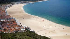 Sem sol e com poucos banhistas, a época balnear arrancou hoje com mais gente na marginal e nas esplanadas do que na praia da Nazaré, onde não falta espaço para cumprir distâncias de segurança, Nazaré, Leiria, 6 de junho de 2020. Com algumas nuvens a toldar o sol e a tornar a praia menos convidativa, era na marginal da Nazaré que manhã cedo se concentrava o movimento, com passeantes e atletas a cruzarem-se no passeio largo. PAULO CUNHA /LUSA