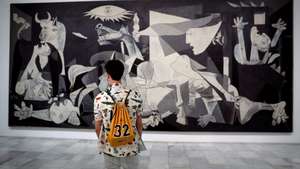 epa08462706 A man looks at Pablo Picasso's 'Guernica' displayed at Reina Sofia Museum in Madrid, Spain, 03 June 2020. Reina Sofia Museum and many others will be reopening on 06 June in the Spanish capital with new security measures due to the coronavirus health crisis.  EPA/CHEMA MOYA