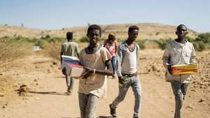 epa08858049 Ethiopian refugees from Tigray region with aid at the Um Rakuba refugee camp, the same camp that hosted Ethiopian refugees during the famine in the 1980s, some 80 kilometers from the Ethiopian-Sudan border in Sudan, 30 November 2020 (issued 02 December 2020). According to World Food Programme on 02 December, about 12,000 Ethiopian refugees from Tigray are accomodated in the Um Rakuba camp as over 40,000 Ethiopian refugees fleed to Sudan since the start of fights in the northern Tigray region of Ethiopia. Ethiopia's military intervention   comes after Tigray People's Liberation Front (TPLF) forces allegedly attacked an army base on 03 November 2020 sparking weeks of unrest. According to reports on 02 December 2020, UN reached an agreement with Ethiopian government to provide aid for the Tigray region of Ethiopia.  EPA/ALA KHEIR