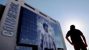 epaselect epa08847393 A man observes a giant banner with a photograph of former Argentine soccer player Diego Armando Maradona, as a tribute, on the facade of the South American Football Confederation (CONMEBOL) building, in Luque, Paraguay, 27 November 2020.  EPA/Nathalia Aguilar