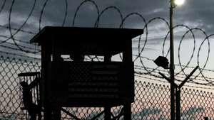 epa05488797 (FILE) A file picture dated 16 February 2006 shows a Joint Task Force member (L, silhouetted) climbing to his guard tower post surrounded by triple rows of razor barbed wire that perimeter the security of Camp Delta, Guantanamo Naval Sation, Cuba. According to media reports on 16 August 2016, the US has sent 15 Guantanamo Bay (GTMO) inmates, 12 Yemenis and three Afghanis, to the United Arab Emirates (UAE). The transfer, the largest under US president Barack Obama's administration, has brought the total number of prisoners in the US military prison down to 61, media added quoting the Pentagon.  EPA/JOHN RILEY