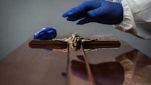 CONJUNTO DE 30 FOTOGRAFIAS SOBRE UM ANO DE ESTADO DE EMERGÊNCIA: 20-30: Foto datada de 30/01/2021: Um funcionário de uma agência funerária coloca uma imagem de Jesus Cristo em um caixão de uma mulher que morreu vítima de covid-19, na Amadora, 30 de janeiro de 2021. Esta semana Portugal ultrapassou as 300 mortes diárias por covid-19, um novo máximo desde o início da pandemia. MÁRIO CRUZ/LUSA