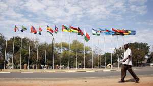 epa04358205 A man walks past the flags of the member states in the 34th Ordinary SADC Summit of Heads of State and Government, Victoria Falls, Zimbabwe, 17 August 2014. The chair of Southern African Development Community (SADC) is now taken by President Robert Mugabe for the following year.  EPA/AARON UFUMELI