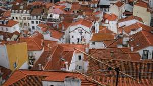 epa09282366 A man works on a roof at Bairro de Alfama in Lisbon, Portugal, 18 June 2021. TheÂ Portuguese cabinetÂ announced on 17 June the ban on circulation to and from the Lisbon Metropolitan Area (AML) on weekends, starting at 15:00 on 18 June, due to the rise in cases ofÂ Covid-19 in this territory.  EPA/MARIO CRUZ