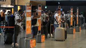 epa10116910 Passengers wait in line at a check-in desk at El Prat Airport in Barcelona, Spain, 12 August 2022. The first day of the EasyJet pilots&#039; strike in August has caused cancellations at El Prat and in Palma de Mallorca Airports.  EPA/ALEJANDRO GARCIA