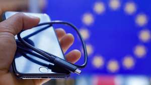 epa10000419 An Iphone with USB-C cable, at the European Parliament in Strasbourg, France, 07 June 2022. The EU have reached an agreement on legislation that will force all future smartphones sold in the EU including Apple's iPhone to be equipped with the USB-C port for wired charging by fall 2024.  EPA/JULIEN WARNAND