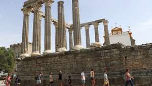 Turistas procuram a sombra ao visitar o Templo Romano, quando em Évora os termómetros ao final da manhã chegam aos 40 graus, 13 de julho de 2022. Devido a uma onda de calor em Portugal continental, que dura há vários dias, são esperadas temperaturas acima dos 45 graus em vários pontos do Alentejo e Ribatejo. NUNO VEIGA/LUSA
