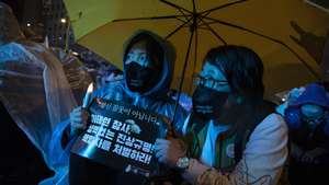 epa10301312 Members of South Korean Confederation of Trade Unions (KCTU) hold a condolences message during a candlelight vigil for the victims of the Seoul Halloween stampede, in Seoul, South Korea, 12 November 2022. Some 10,000 people gathered to demand the punishment of those responsible within the government. At least 156 people died following a deadly stampede that occurred during Halloween celebrations in the Itaewon district of Seoul on 29 October.  EPA/JEON HEON-KYUN