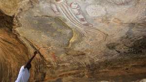 Paihama Catenga, responsável da área de cultura e turismo da Administração Municipal do Virei, mostra uma das pinturas rupestres de Tchitundo-Hulo, discretamente desenhadas em grutas remotas do sul de Angola, estão entre os vestígios arqueológicos mais importantes do país, mas a falta de proteção ameaça o valioso património, em Moçâmedes, município do Virei, província do Namibe, Angola, 16 de novembro de 2022. Diz-se que “caíram do céu” - o significado de Tchitundo-Hulo na língua local - e encontram-se a cerca de 130 quilómetros da sede do município do Virei, província do Namibe, numa região desértica à qual se acede seguindo uma picada arenosa. (ACOMPANHA TEXTO DA LUSA DO DIA 04 DE DEZEMBRO DE 2022). AMPE ROGÉRIO/LUSA