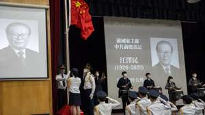 epa10350907 Secondary school students attend a flag-raising ceremony during a memorial service for former Chinese leader Jiang Zemin in Hong Kong, China, 06 December 2022. Former Chinese President for Jiang Zemin passed away in Shanghai last week, at the  age of 96.  EPA/JEROME FAVRE