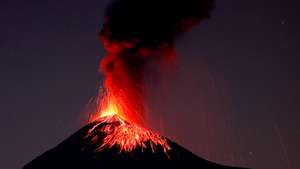 epa09701055 A slow shutter photo shows smoke, fire, and ashes during an explosion of the volcano of Fuego from Alotenango, Guatemala, 21 January 2022.  EPA/Esteban Biba