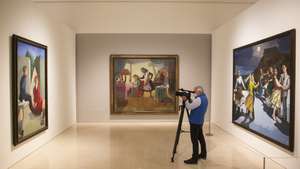 epa09909847 A camera man stands between the artworks 'The Maids' (C), 'The Cadet and his Sister' (L) and 'The Dance' (R) by Portuguese artist Paula Rego during the opening of the exhibition 'Paula Rego' at the Picasso Museum in Malaga, southeastern Spain, 26 April 2022. The exhibition is organized by the Tate Britain in collaboration with the Kunstmuseum Den Haag and the Malaga Picasso Museum, and will be open for the public until 27 August.  EPA/Alvaro Cabrera