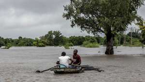 Populares numa embarcação numa área inundada após chuvas desde 07 de Fevereiro em Maputo, Moçambique, 10 de fevereiro de 2023. A chuva intensa que cai na região de Maputo desde quarta-feira já afetou cerca de 14.000 pessoas e desalojou 180 famílias, de acordo com um balanço oficial divulgado hoje pelas autoridades, que mantêm em quatro o número de óbitos. LUÍSA NHANTUMBO/LUSA