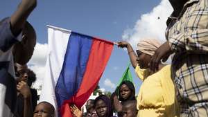 epa10199914 A demonstrator carries a Russian flag during a protest against the United Nations and former occupier France and in support of Russia during Independence Day celebrations in Bamako, Mali, 22 September 2022. The protestors called for an increased Russian presence in Mali as it faces condemnation for detaining 46 soldiers from neighboring Ivory Coast that had been deployed to provide security for a company contracted by the United Nations.  EPA/HADAMA DIAKITE