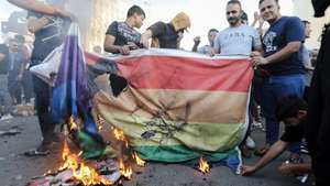 epa10719869 Iraqi demonstrators burn a rainbow flag, symbol of the international LGBT community, during a protest near the Swedish embassy in Baghdad, Iraq, 30 June 2023. Hundreds of protesters gathered near the Swedish embassy building in Baghdad following a call for an 'angry' demonstration by Iraqi Shiite cleric Muqtada al-Sadr over the burning of a copy of the Koran in Stockholm.  EPA/AHMED JALIL