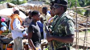Tropas de Moçambique vigiam feira no centro de Mocímboa da Praia, norte de Moçambique, 26 de junho de 2023. Há residentes de etnia maconde que já rumaram a Mueda, no planalto de Cabo Delgado, “para plantar milho”, mas o que os muânis como Assumane sabem fazer é plantar arroz nos campos de Auasse, ali perto de Mocímboa de Praia. (acompanha texto de 26 de junho de 2023). LUÍS FONSECA/LUSA