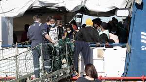 epa09662505 Some of the 440 migrants rescued at sea disembark from &#039;SeaWatch 3&#039; at the port of Pozzallo, Sicily, Italy, 01 January 2022. The German NGO migrant rescue ship Sea Watch 3 with 440 migrants on board arrived on 31 December 2021 in the port of Pozzallo. The ship was at sea since Christmas Eve after carrying out five rescue missions.  EPA/FRANCESCO RUTA