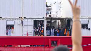 epaselect epa10824962 A person flashes a victory sign towards migrants aboard the &#039;Ocean Viking&#039;, the SOS Mediterranee ship that rescued 439 migrants between Lampedusa and Tunisia, as they arrive in the port of Naples, Italy, 28 August 2023.  EPA/CIRO FUSCO