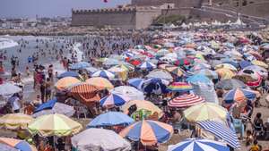 epa10792070 People gather on the beach during a hot summer day in Rabat, Morocco, 09 August 2023. According to the Moroccan General Directorate of Meteorology, temperature in Rabat fell to 28 Celsius degrees after a two-day heatwave that affected several Moroccan provinces with temperatures soaring to 44 Celsius degrees.  EPA/JALAL MORCHIDI