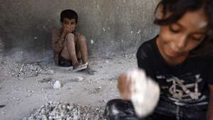 epa11558048 Palestinian children break up stones collected from homes destroyed by previous Israeli air strikes, to sell them to make gravestones, in Khan Younis, southern Gaza Strip, 21 August 2024. More than 40,000 Palestinians and over 1,400 Israelis have been killed, according to the Palestinian Health Ministry and the Israel Defense Forces (IDF), since Hamas militants launched an attack against Israel from the Gaza Strip on 07 October 2023, and the Israeli operations in Gaza and the West Bank which followed it.  EPA/HAITHAM IMAD