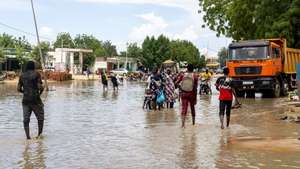 epa11558167 People walk in a flooded street in N&#039;Djamena, Chad, 21 August 2024. Flooding caused by rainfall and strong winds have been affecting central and south-western Chad, according to the UN Office for the Coordination of Humanitarian Affairs (OCHA), which reported more than 5,300 displaced people, 261,000 people affected by floods and 16,200 damaged or destroyed houses from 15 July to 15 August 2024.  EPA/CHANCELIN MBAIRAMADJI MOITA