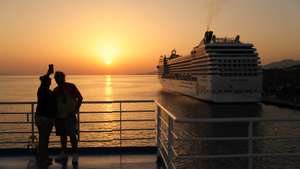 epa10762787 Tourists take photos of the sunset on board while traveling to Mykonos Island, Greece, 22 July 2023.  EPA/GEORGE VITSARAS