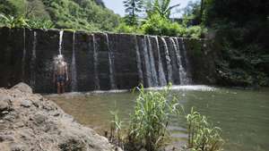 Anilton Fortes, 39 anos, desfruta do “luxo de ter uma cachoeira” enquanto se banha na Cachoeira Maravilha, localizada na zona de Picos, na Ilha de Santiago, em Cabo Verde, 11 de outubro de 2024. (ACOMPANHA TEXTO DE 14-10-2024) ELTON MONTEIRO/LUSA